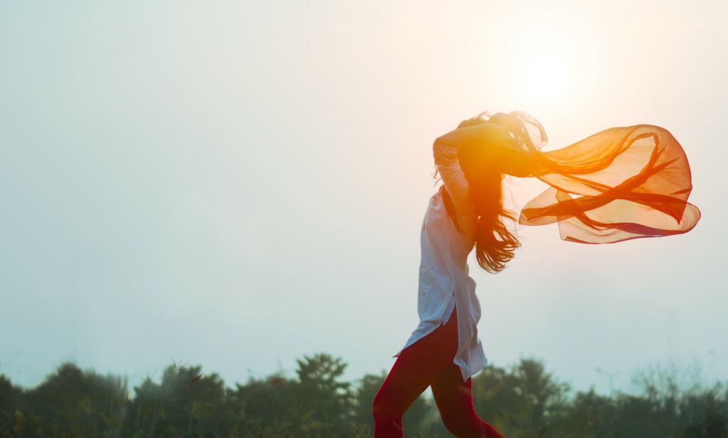 Woman in sun representing joy and well-being.